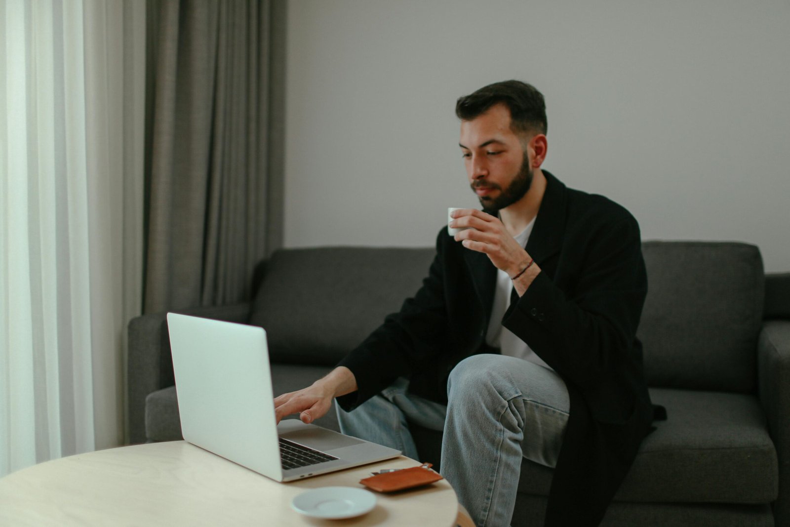 Person relaxed at laptop with coffee, representing the relief of organized task management