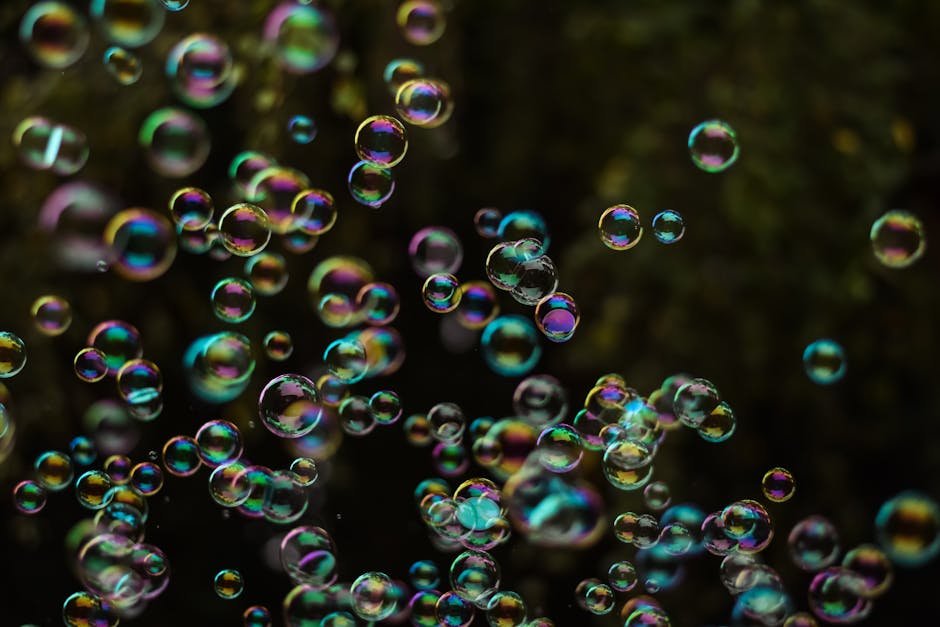 Colorful soap bubbles floating against dark background representing the fragile nature of market bubbles