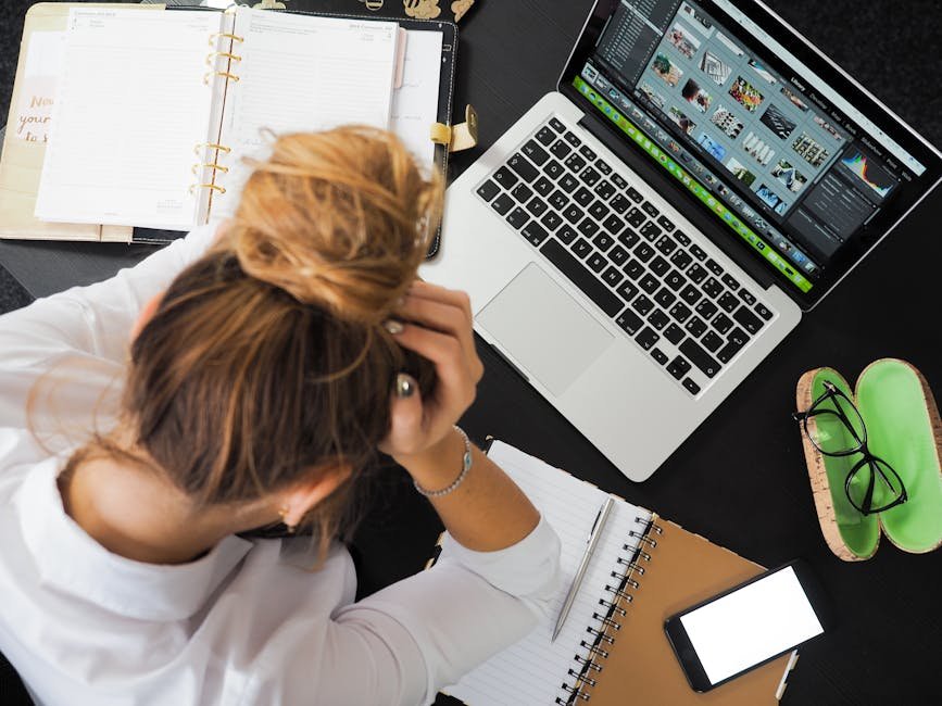 Person feeling overwhelmed at desk with laptop, depicting writing stress before AI help