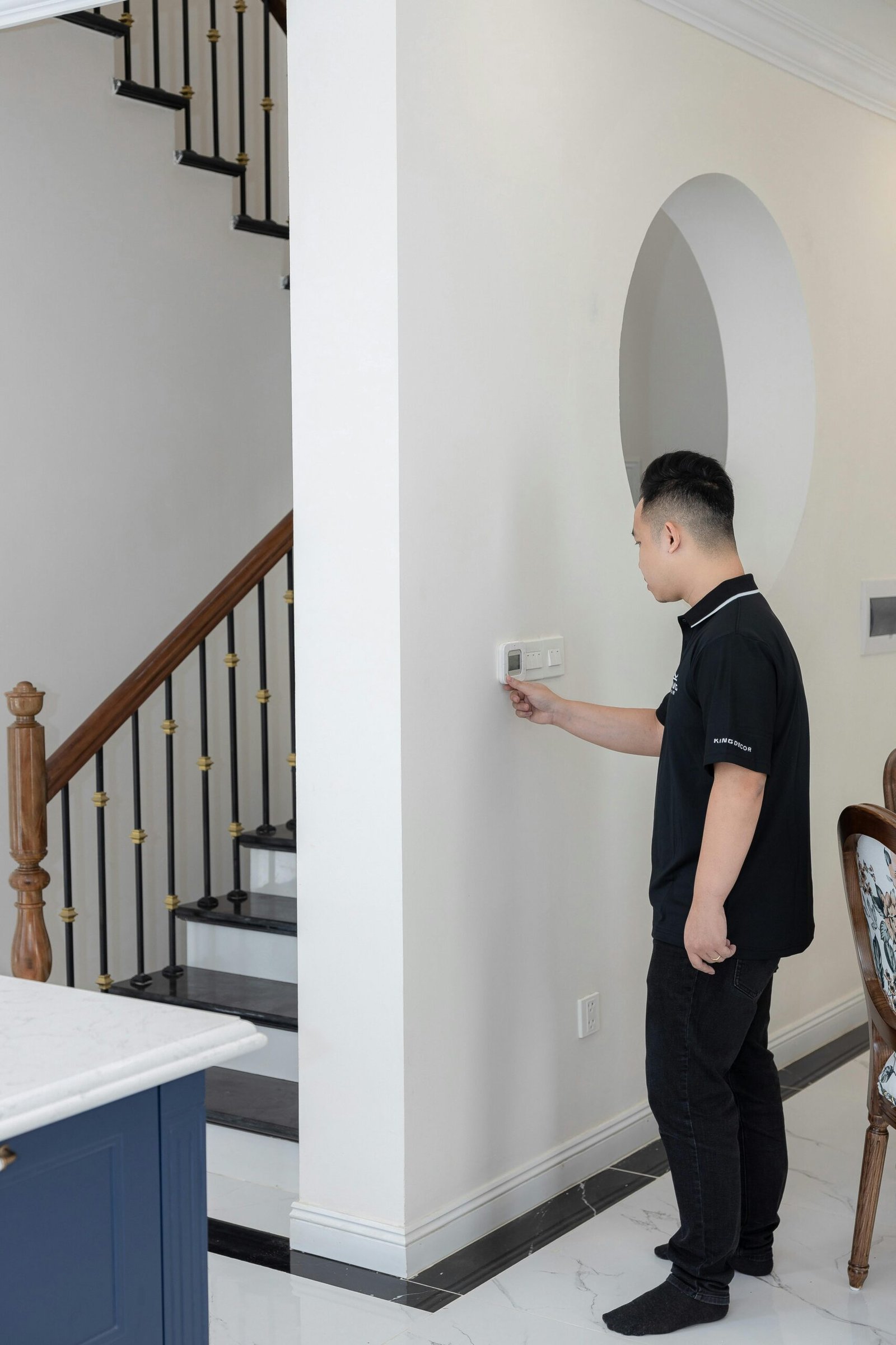 Man adjusting smart thermostat as part of AI home maintenance system