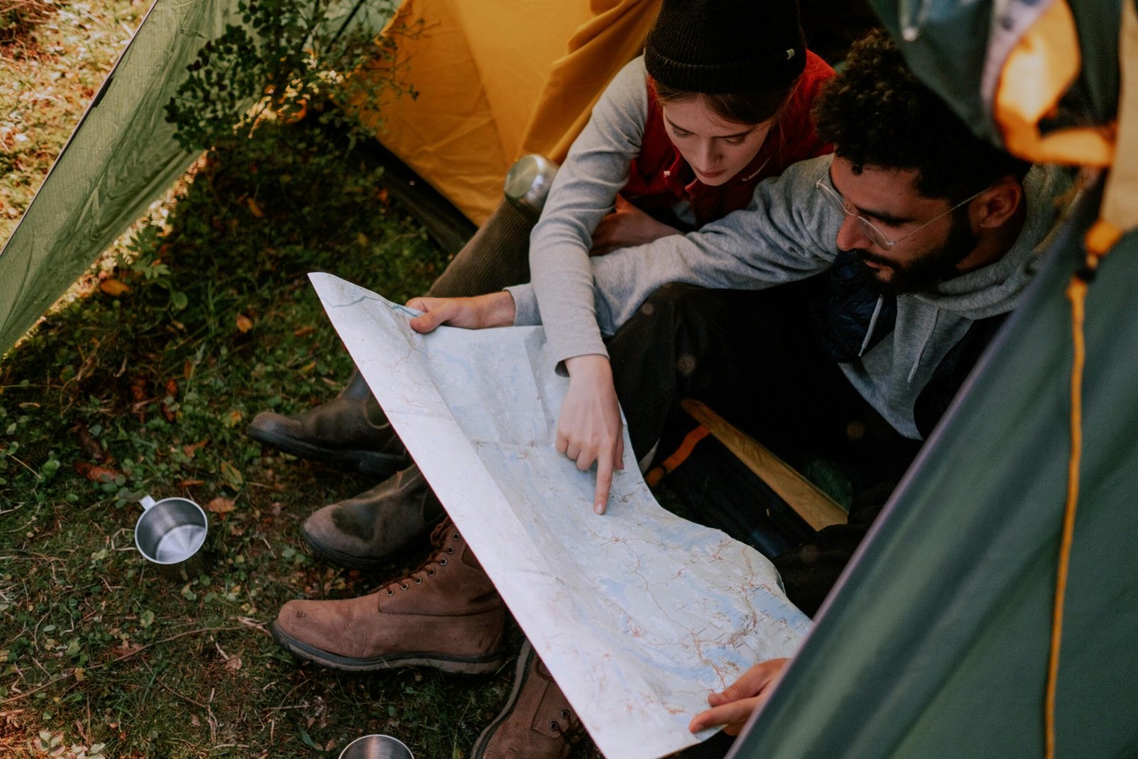 Couple using AI travel itinerary planner to examine map while planning outdoor adventure