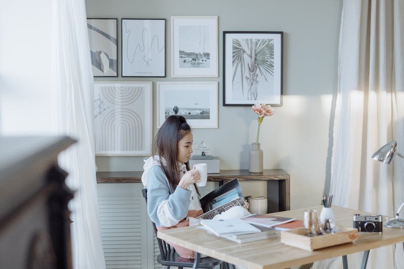 Woman savoring coffee while reading at a stylish desk representing intentional reading habits
