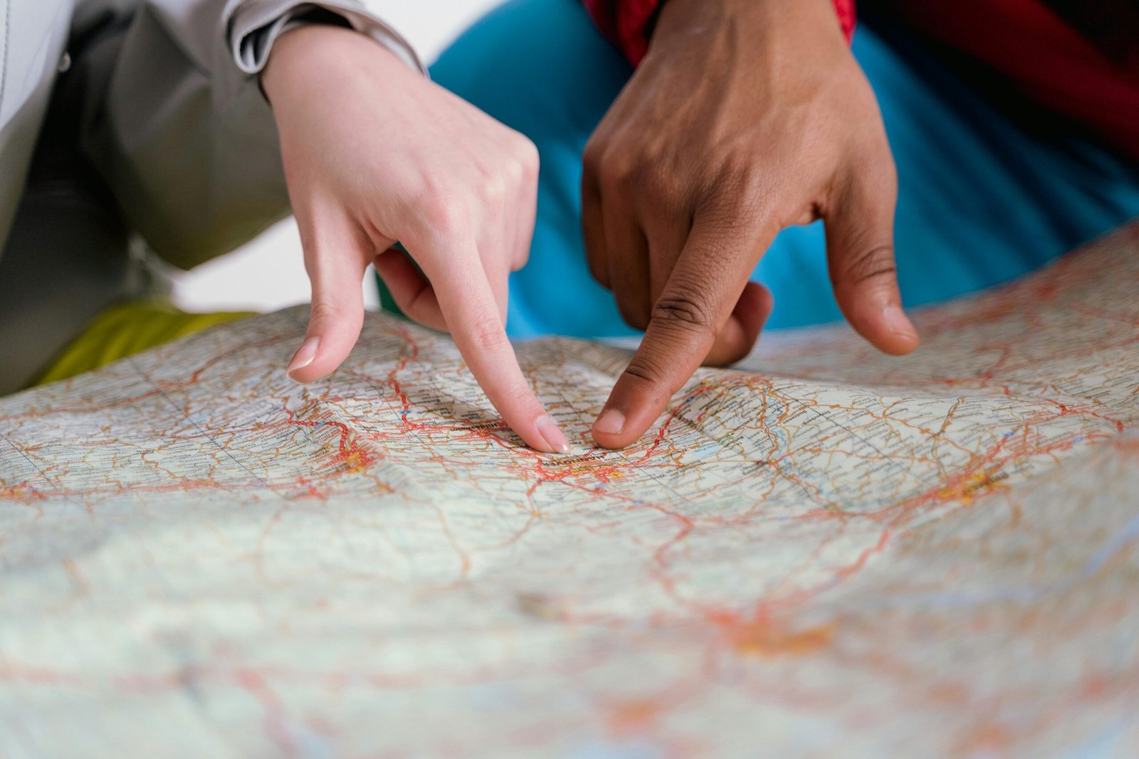 Group planning trip using AI travel itinerary planner with hands pointing at map