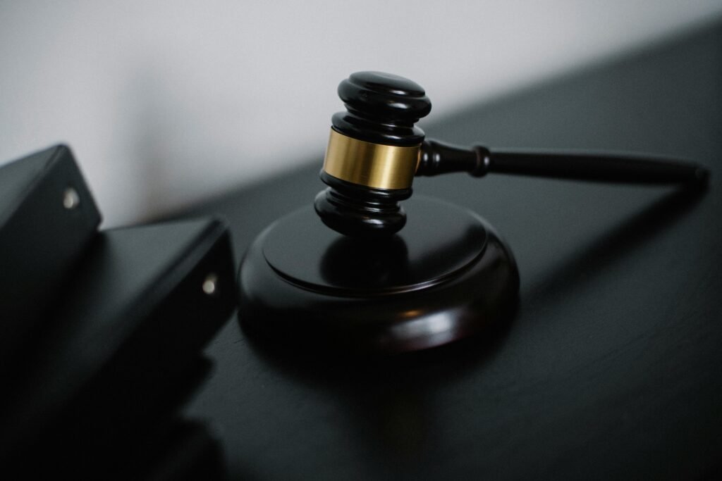 Grok AI Apologizes After Generating Sexualized Images of Minors 3 Close-up of a wooden gavel on a desk, symbolizing justice and legal authority.