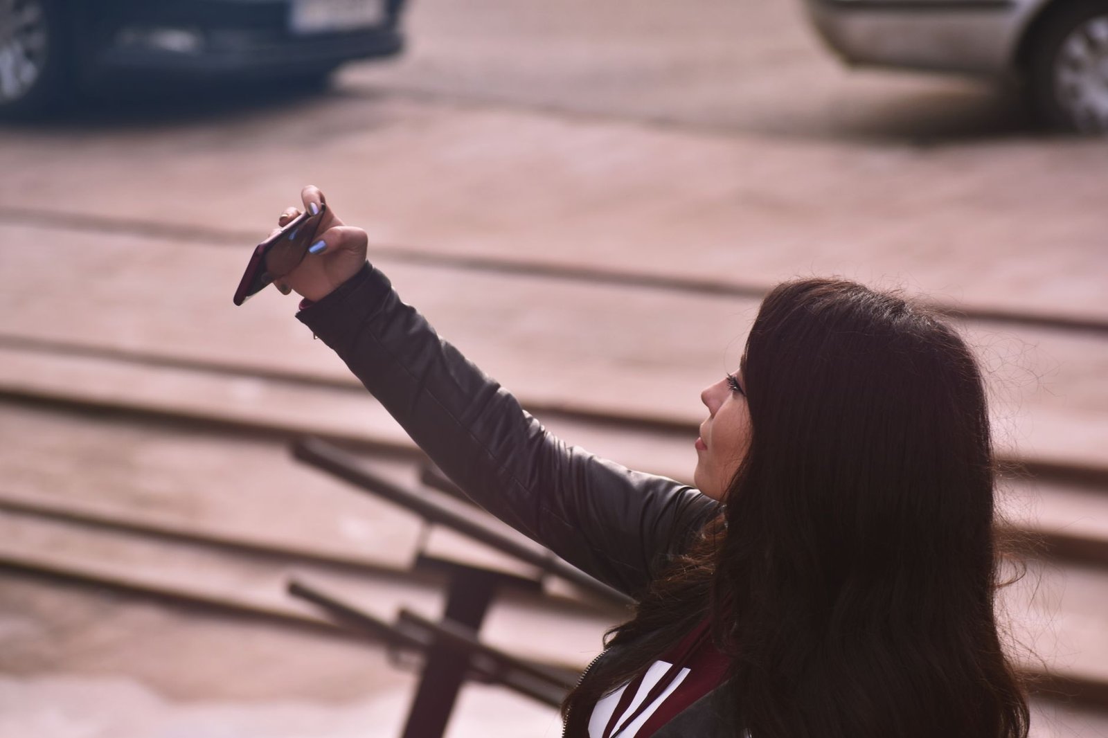 A young woman taking a selfie on her phone, the kind of public photo Meta Muse Image can now use