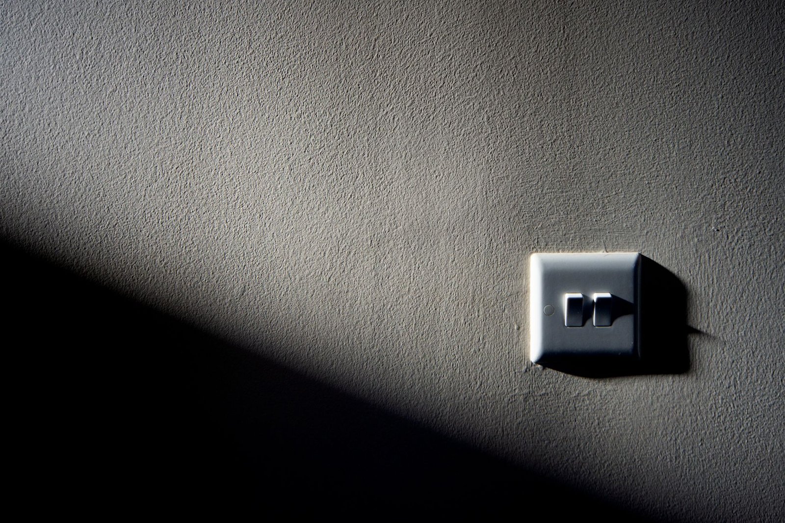 A single light switch on a textured wall, the simple toggle that turns off Google AI Mode