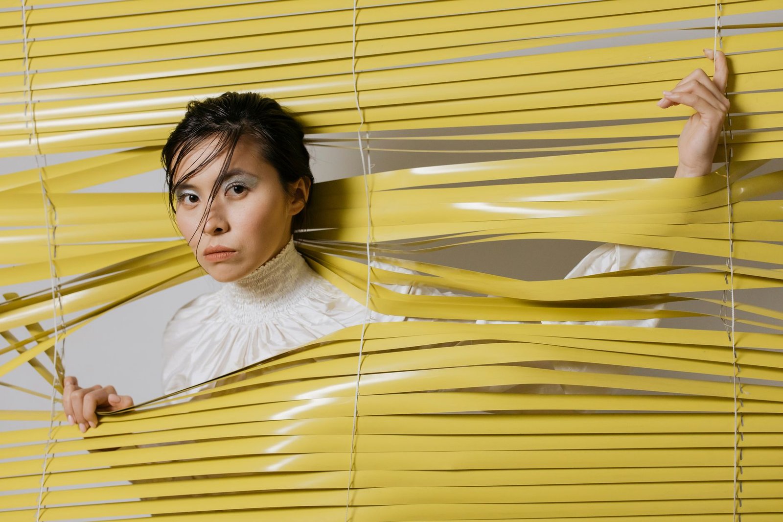 A woman peeking through window blinds, the uneasy feeling of strangers accessing your photos