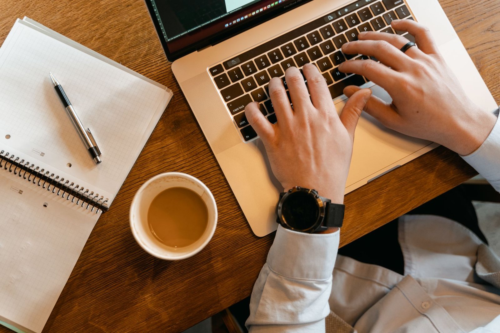 Gemini Study Notebooks: How Google's Free AI Tutor Actually Works 3 Hands typing on a laptop next to a notebook, setting up a study plan