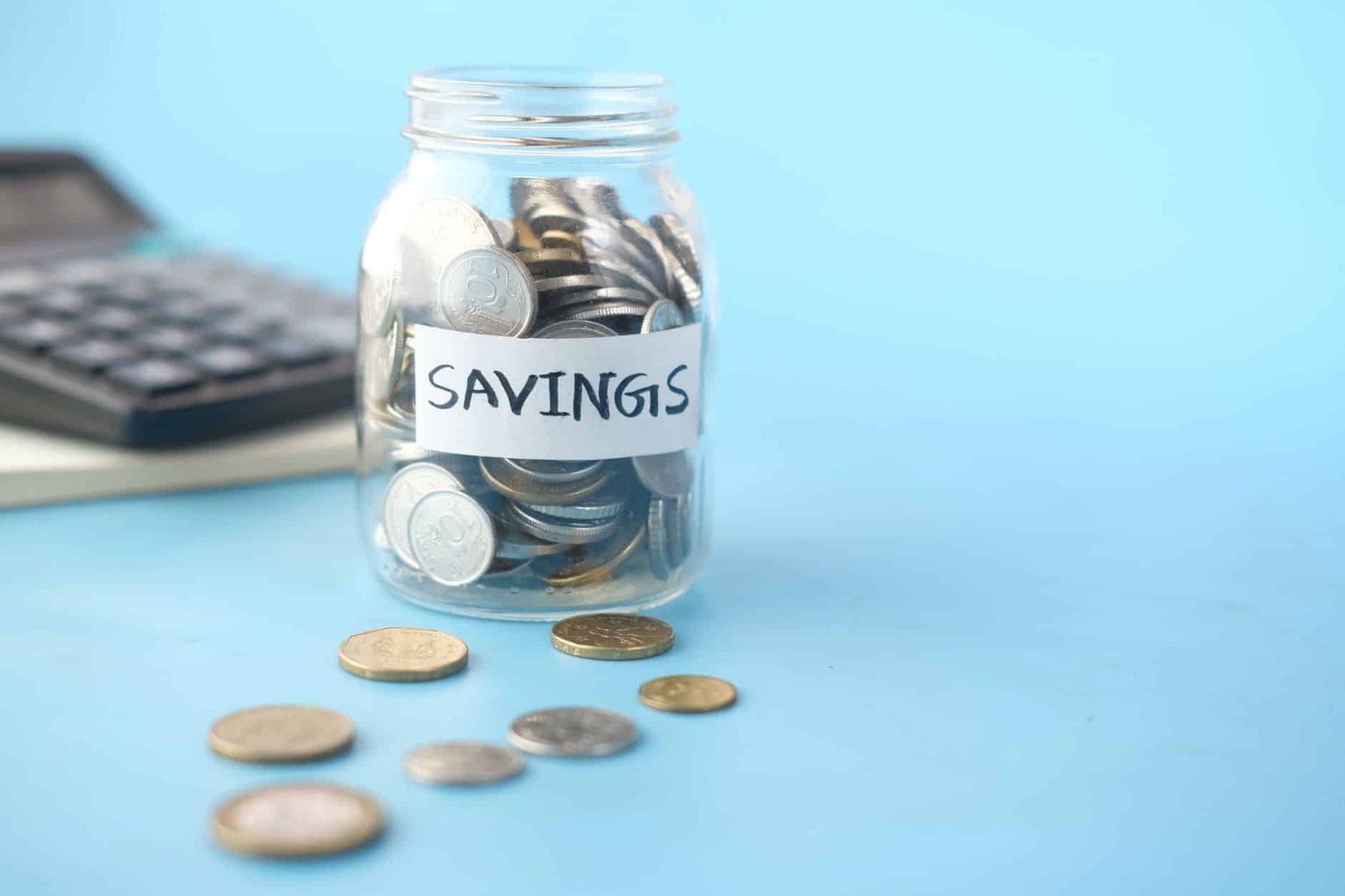 Savings jar full of coins next to a calculator, adding up the cost gap between AI subscriptions
