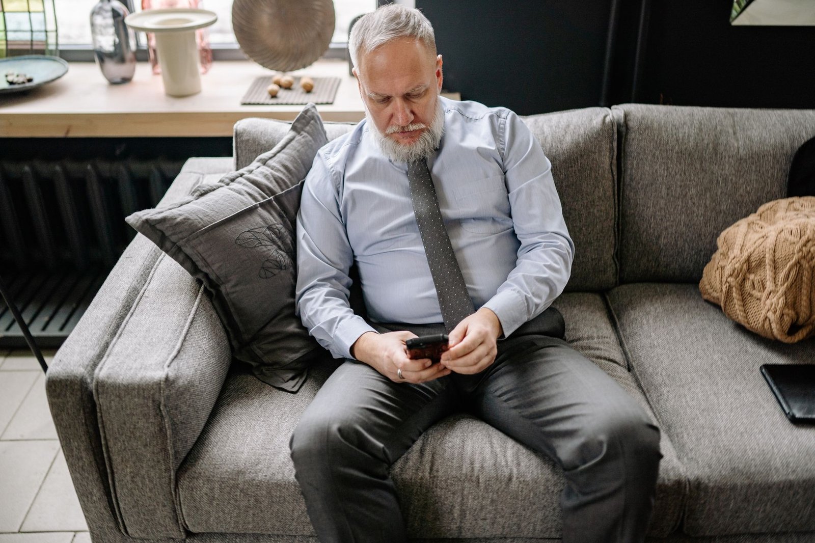 Ring AI Features in 2026: Smarter Alerts and My Honest Take 2 A man checking alerts on his phone from the couch, with fewer junk notifications thanks to Ring AI Unusual Event Alert