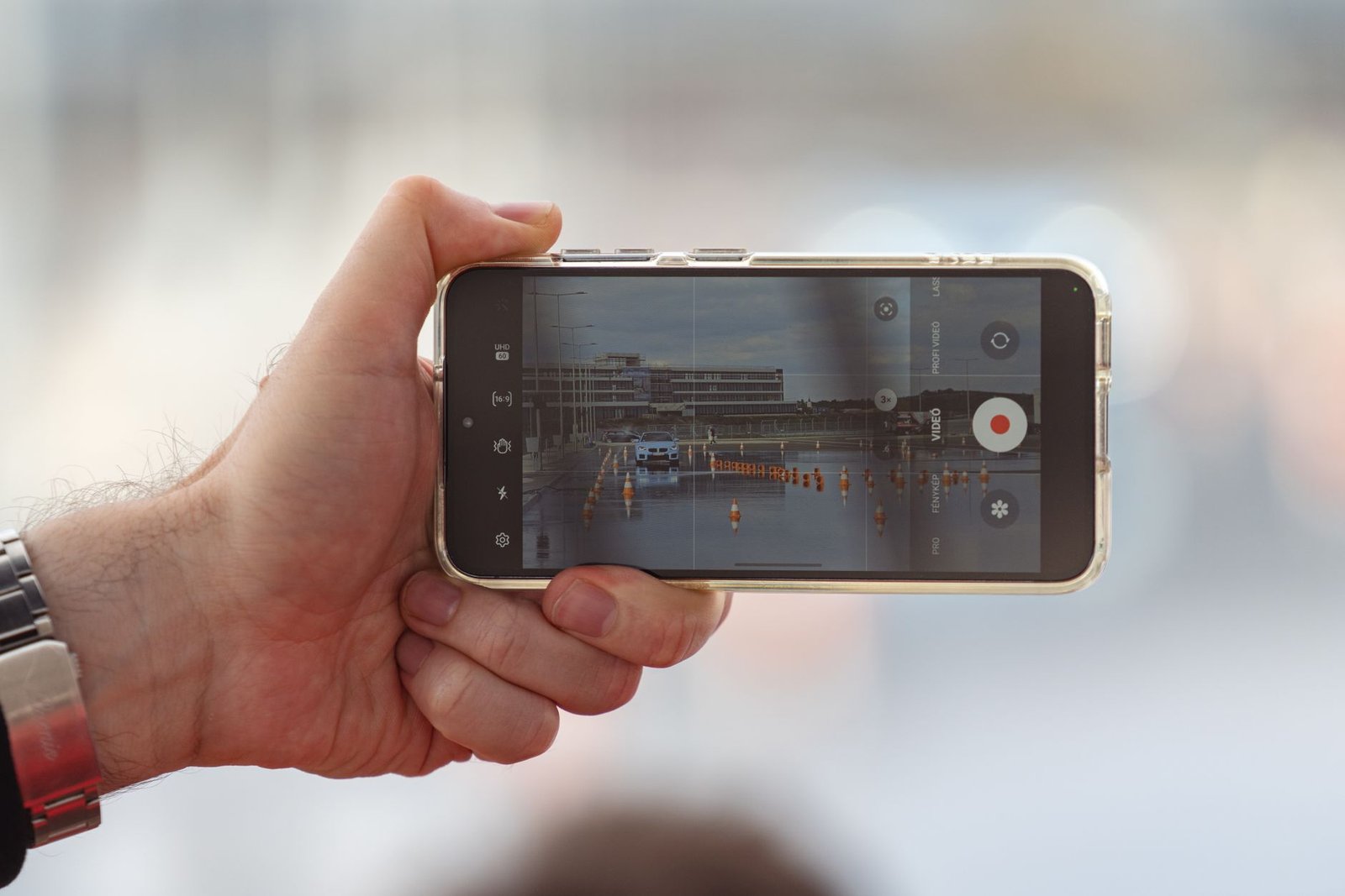 Someone filming a video on a phone, the kind of clip Google Video Remix can relight and restyle in Google Photos