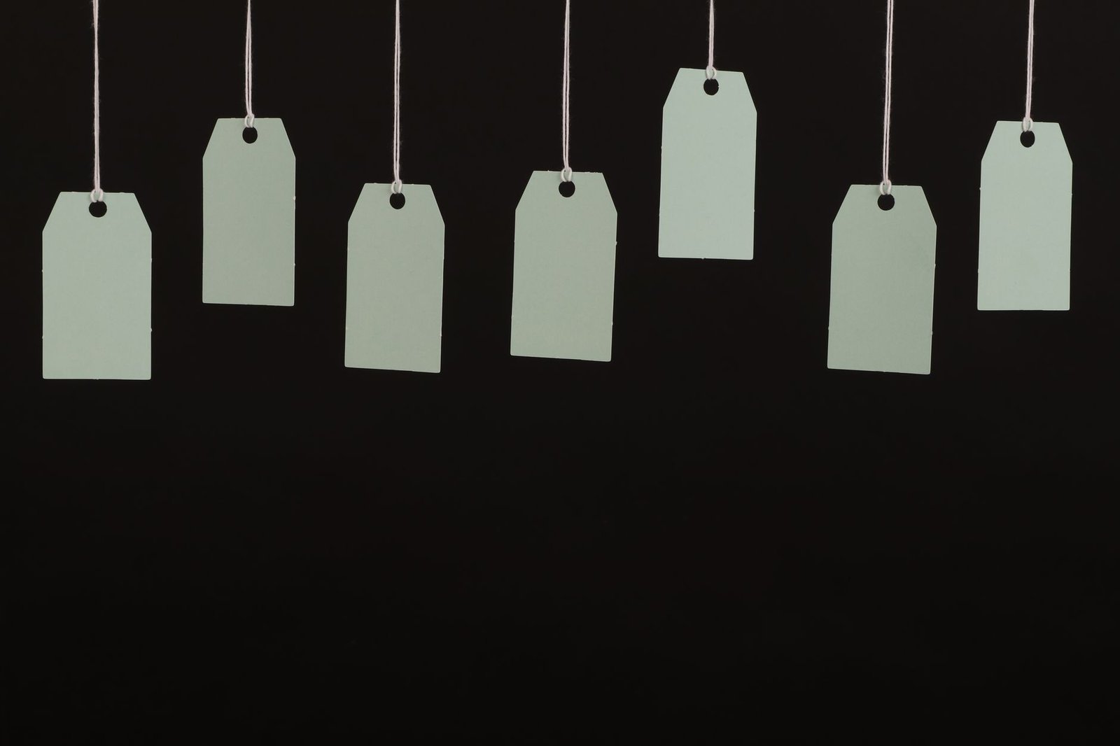 Blank tags hanging on strings, representing the author label attached to each story in the AI-written stories study