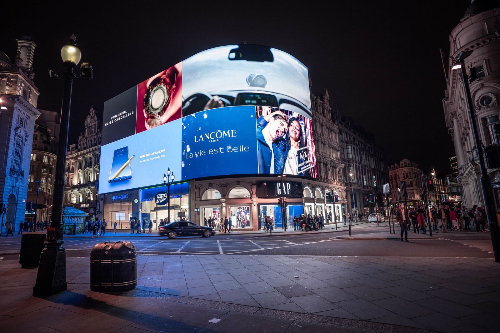 Free ChatGPT Limits: What “Unlimited” Actually Covers 4 Illuminated billboards at night, representing the ads OpenAI now shows free ChatGPT users