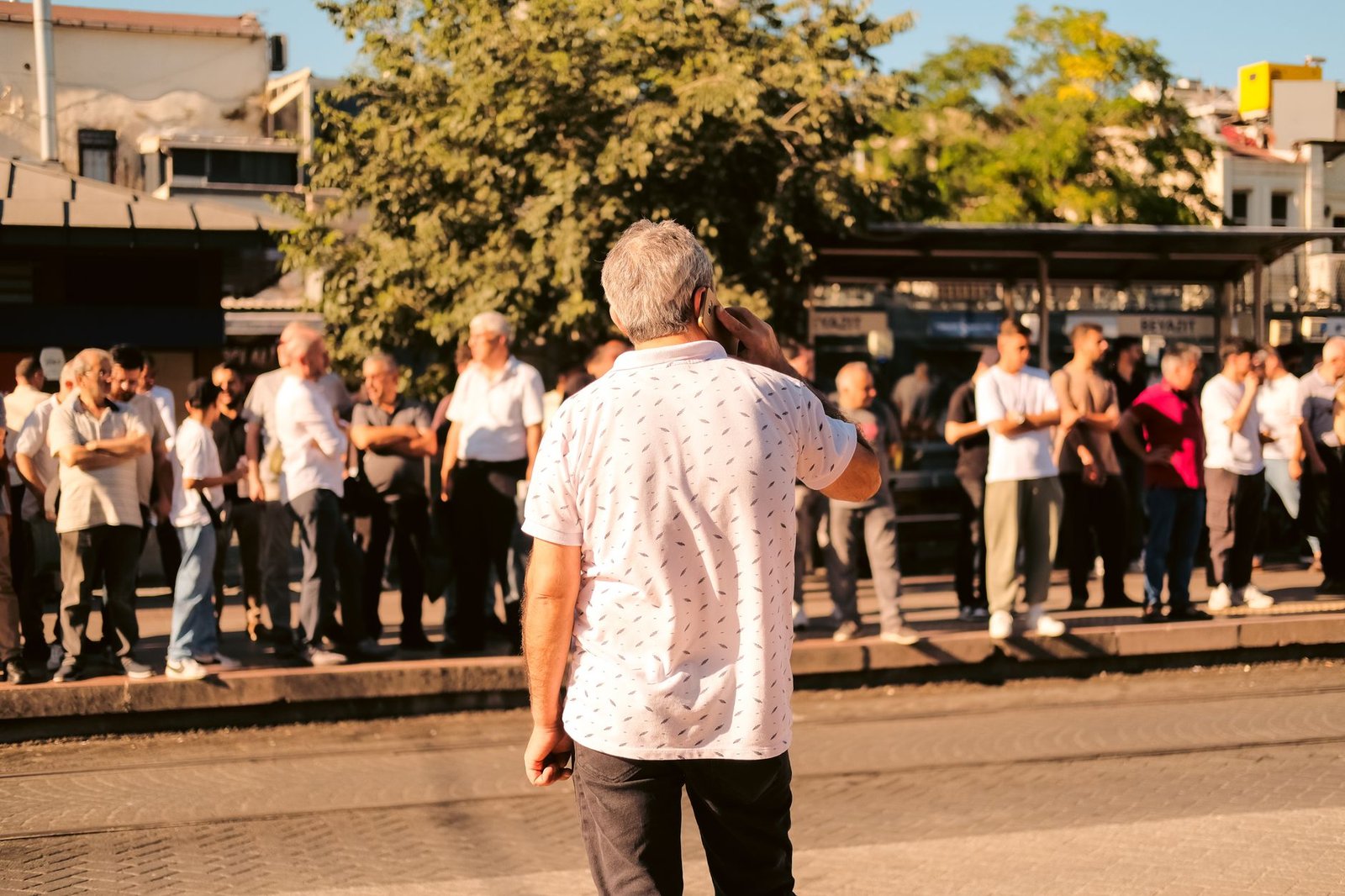 Free ChatGPT Limits: What “Unlimited” Actually Covers 2 People waiting at a sunny bus stop, representing the staged rollout of unlimited text chats