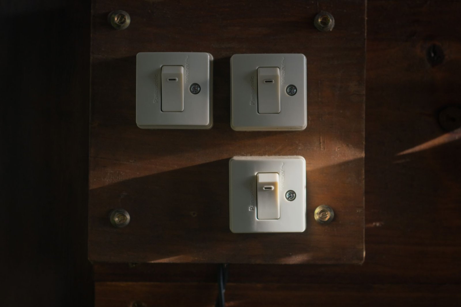 Vintage light switches on a wooden panel, representing the separate Copilot toggle in each Microsoft app