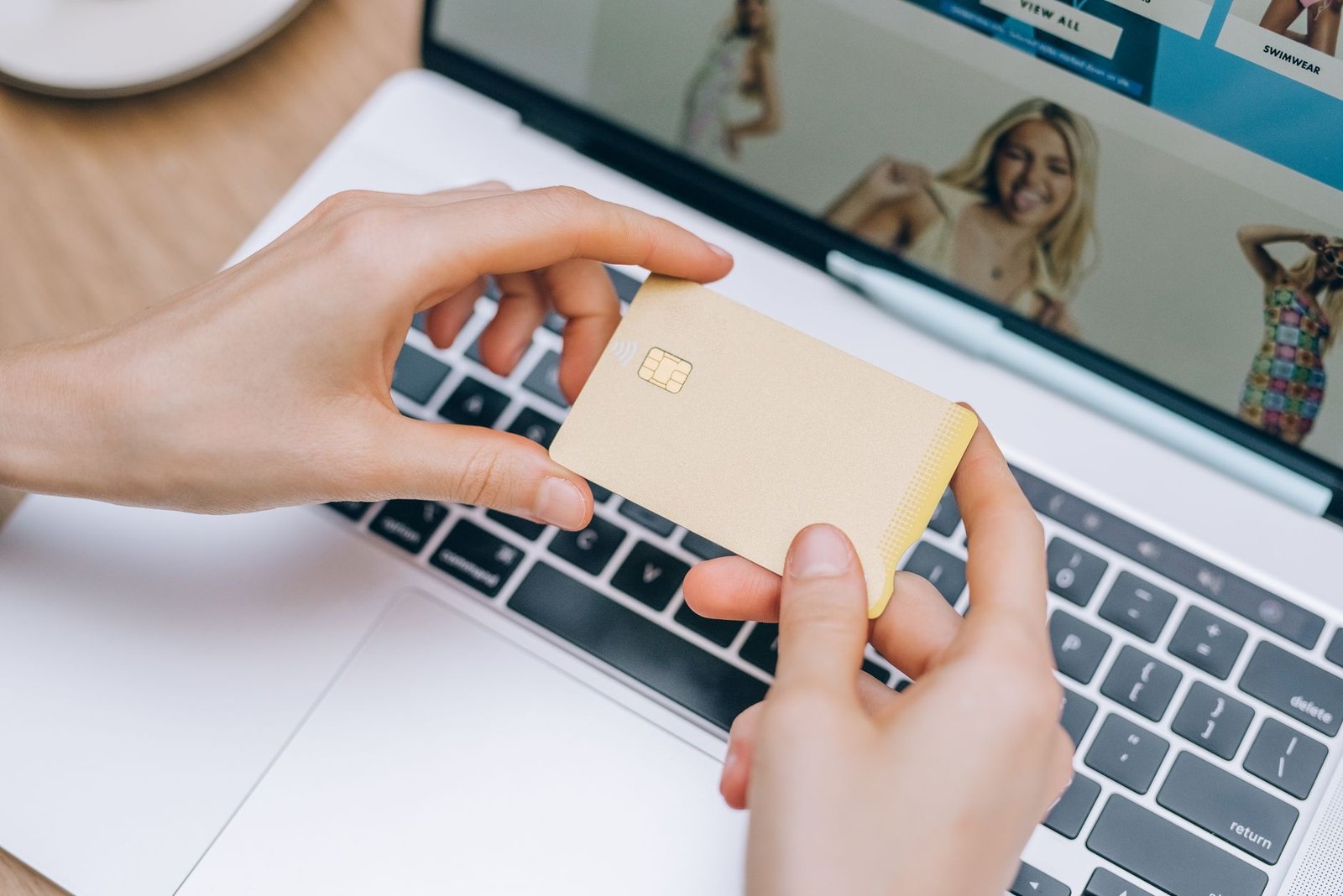 Hands holding a credit card at a laptop, the kind of purchase a Meta Hatch AI agent would make for you