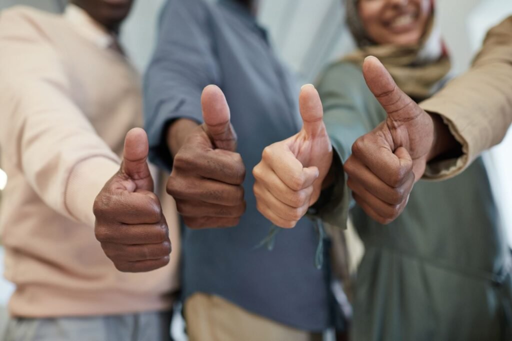 Gemini Task Automation: 40+ Apps Where Your Phone Now Runs the Errands 4 Close-up of a diverse team giving thumbs up indoors, symbolizing success and unity.