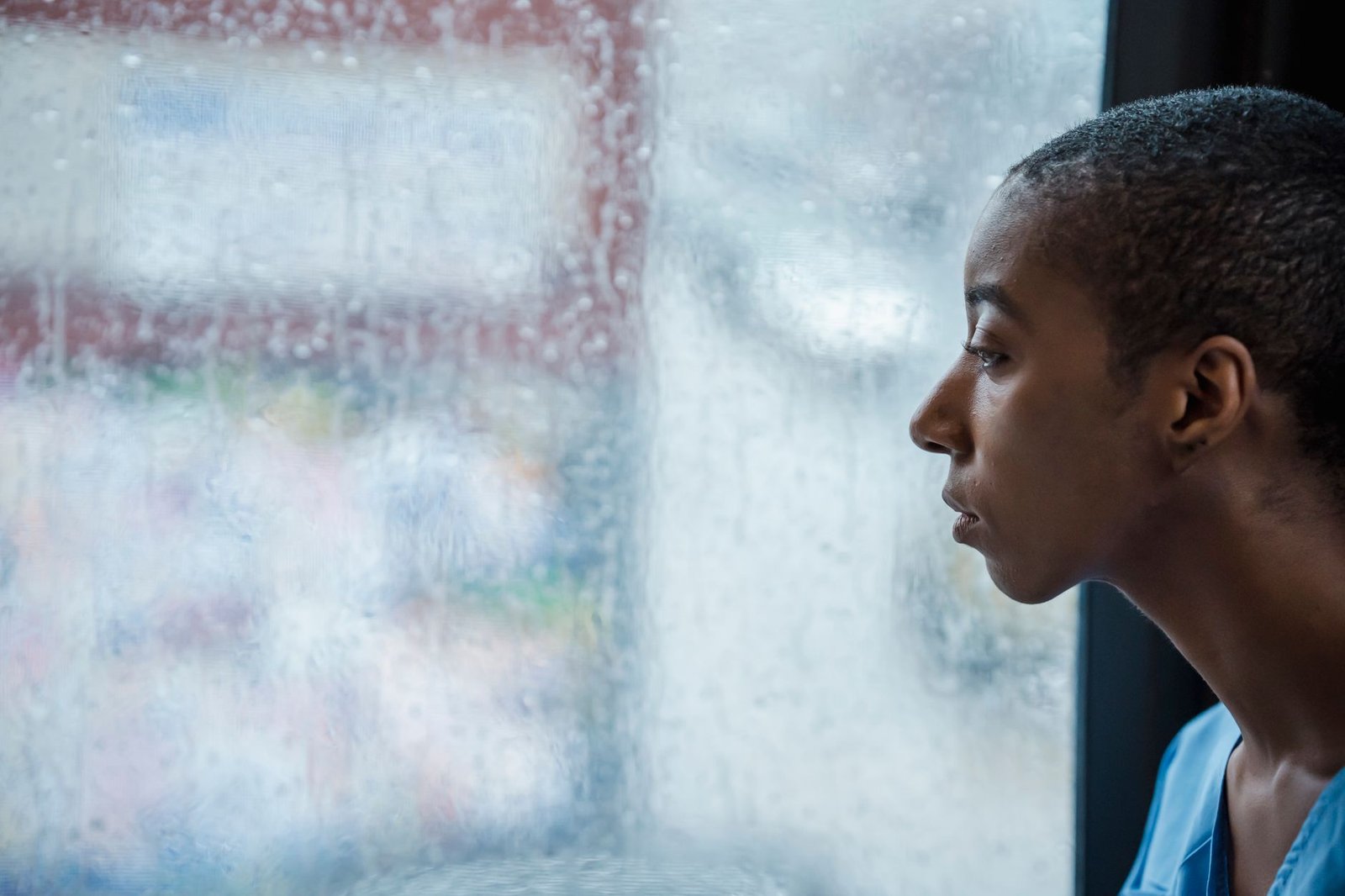 ChatGPT for Teens: What Parents Can Actually Control 6 A young person sitting by a rain-covered window looking away, the kind of heavy chatbot use ChatGPT for Teens break reminders target