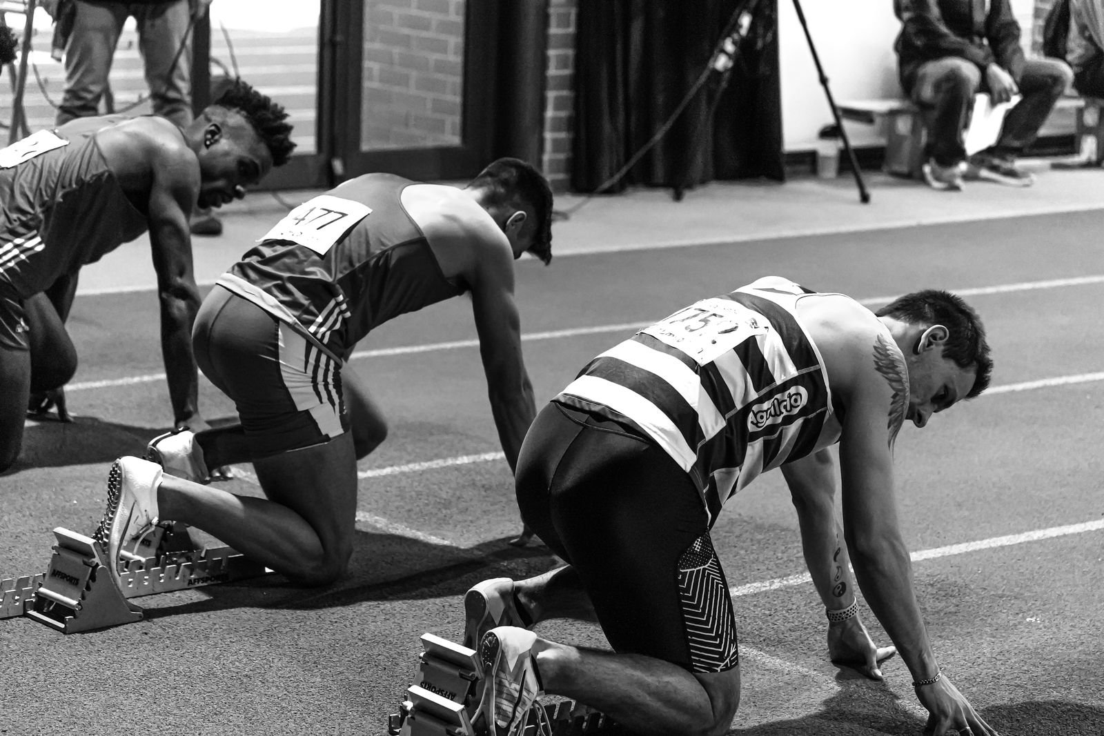 Three sprinters in starting blocks, a stand-in for who's winning the AI race in September 2026