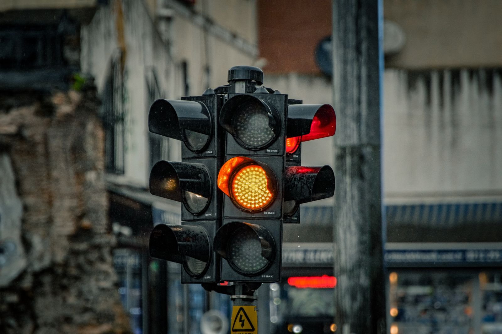An amber traffic light on a rainy street, standing in for the AI slowdown Dario Amodei called for