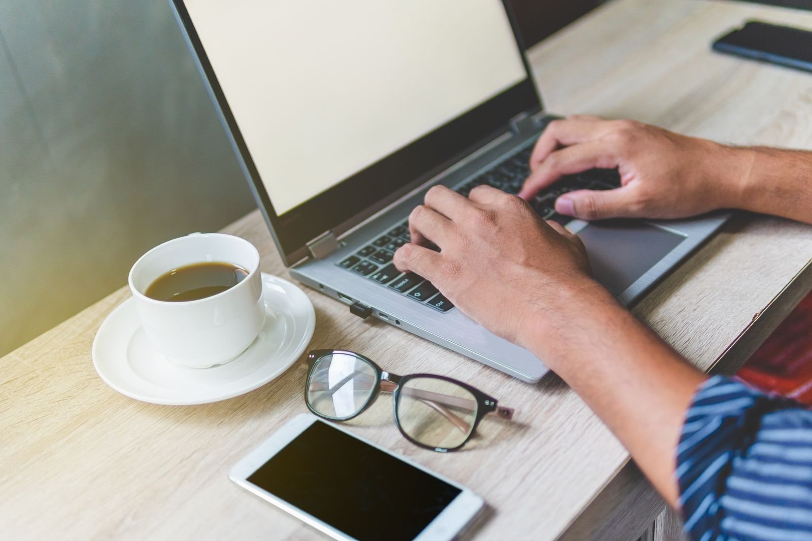 A person typing on a laptop at a desk, the way most Pro and Max users will meet Claude Opus 5.5