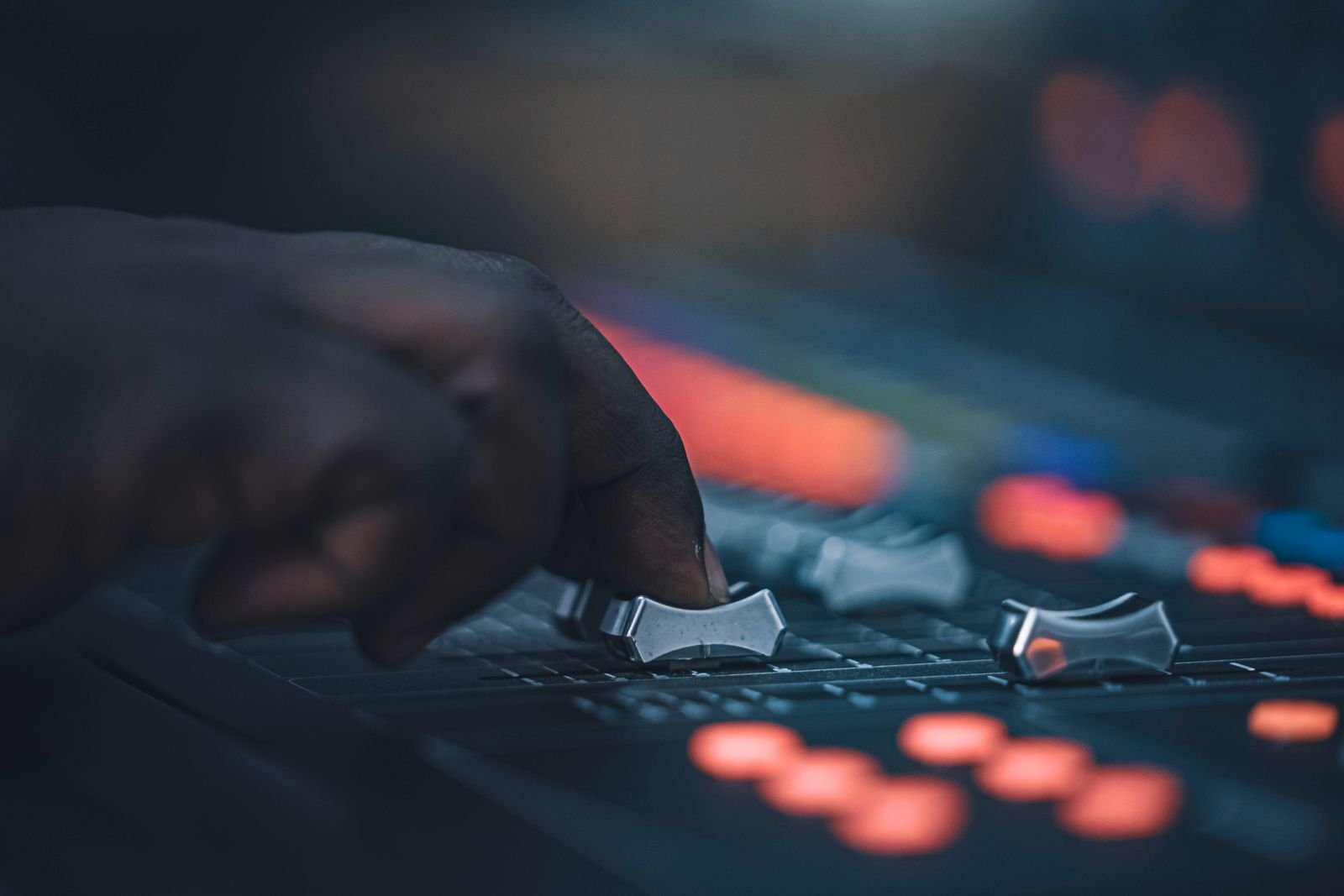A hand adjusting sliders on an audio mixing console, like tuning Gemini's settings on day one after the Google Assistant shutdown