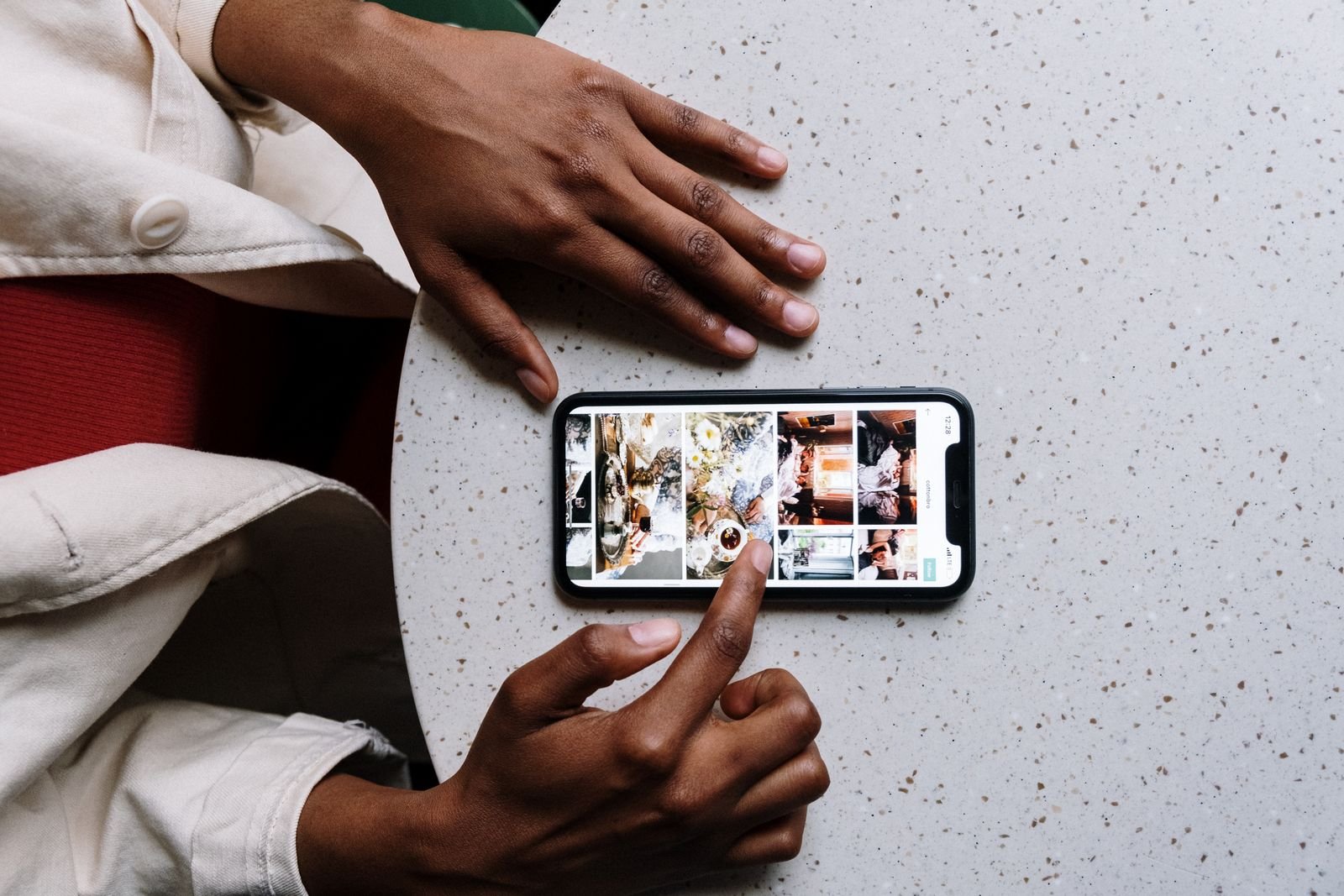 iPhone 18 Pro Price Is Up $100. I Told You AI Memory Would Do This. 3 Someone using their current phone at a cafe table, the phone most people should probably keep this year
