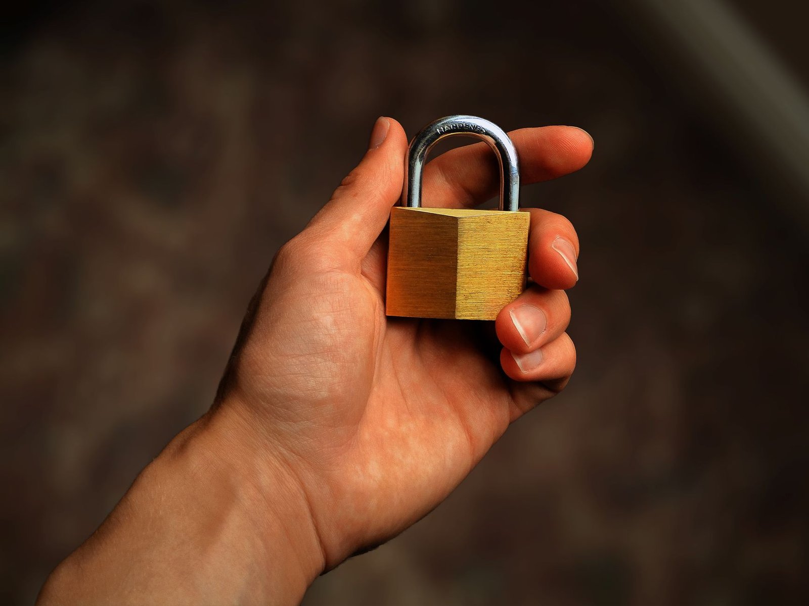 Hand holding a brass padlock, for the privacy settings to check before linking a bank to ChatGPT